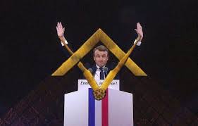emmanuel macron holding his arms in victory with the masonic symbol in front