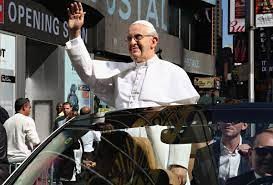 Wax Statue of Pope Francis standing in a car